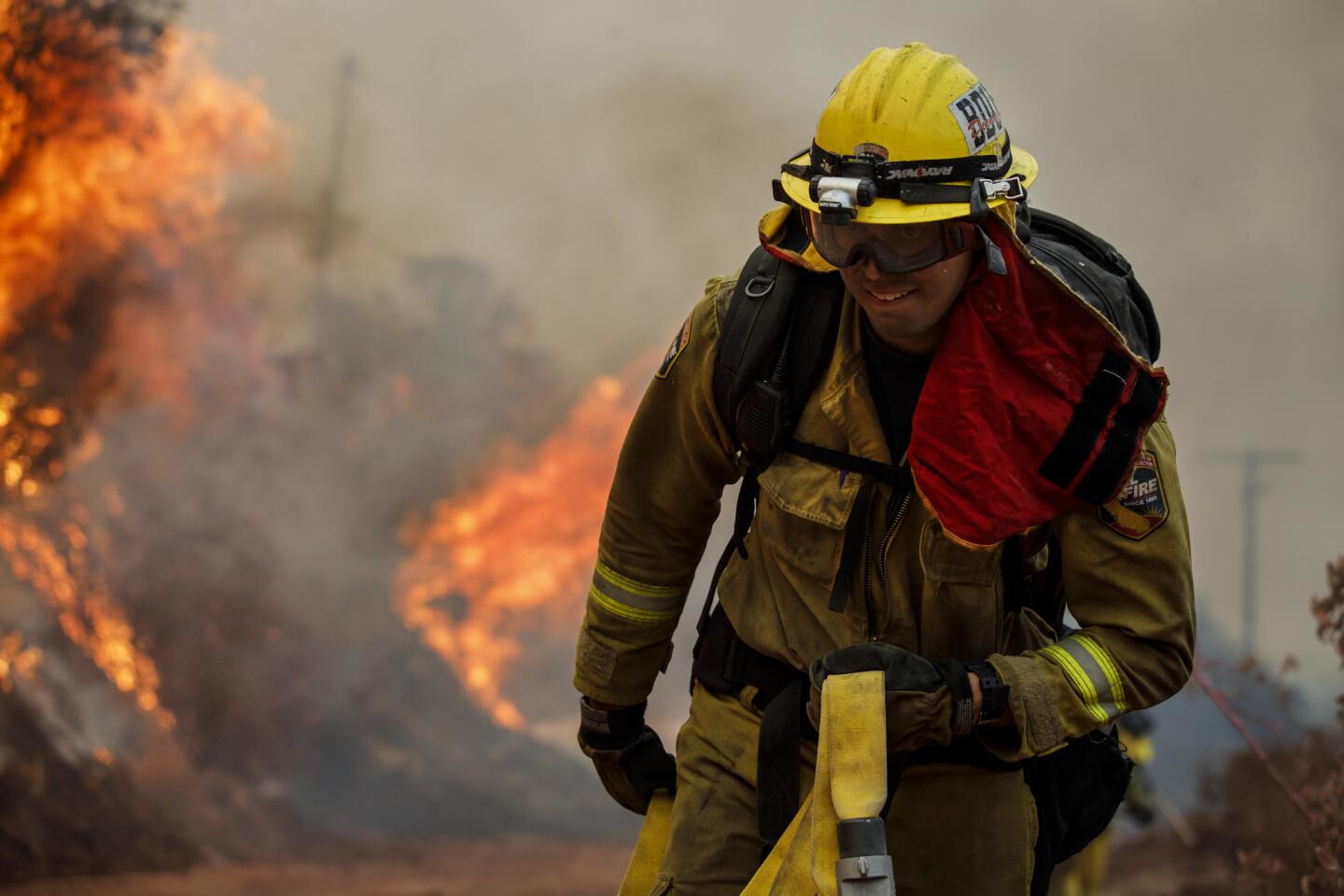 Firefighters try to stop the progression of the Holy fire as it makes its way toward homes due to the strong evening winds from Lake Elsinore.