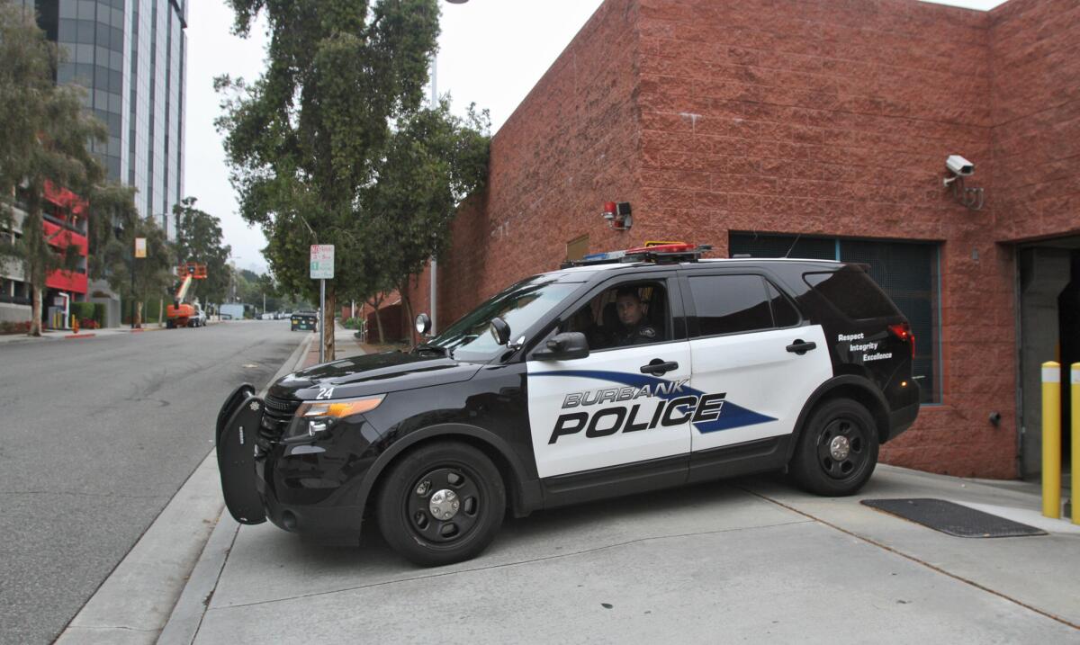 A Burbank police vehicle exits the underground parking garage at police headquarters on April 8.