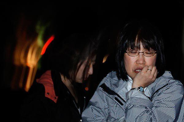 Two women huddle together in Ishinomaki, Japan, after a magnitude 7.1 earthquake struck offshore late Thursday.