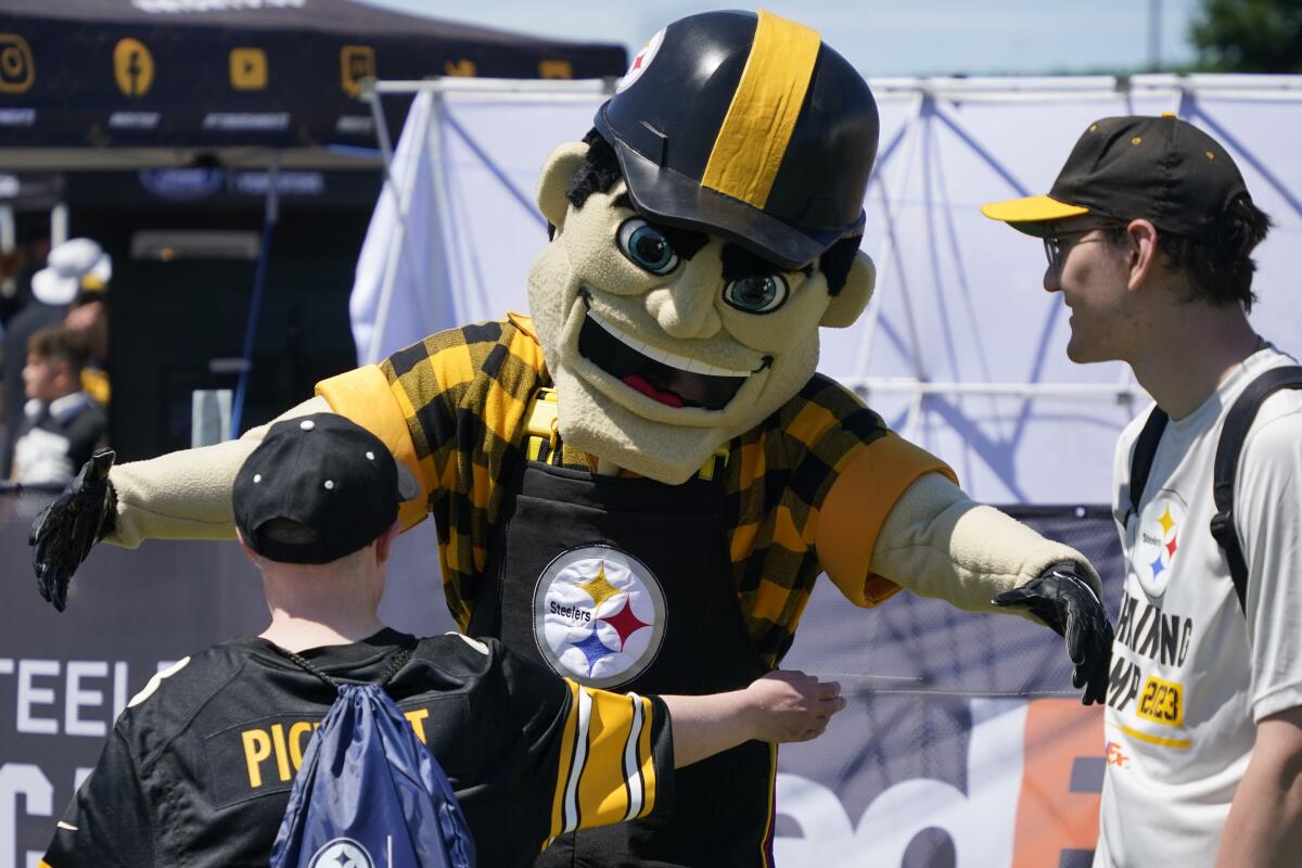 A young Pittsburgh Steelers fan gets a hug from Pittsburgh Steelers mascot Steely McBeam
