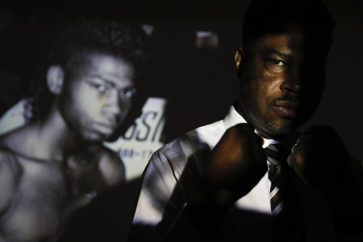 Rodney Jones shown in a silhouette in front of a boxing poster. 