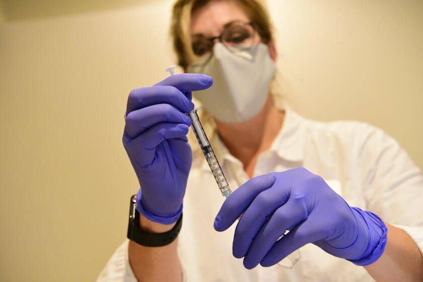 A pharmacist prepares a dose of Johnson & Johnson's experimental COVID-19 vaccine.