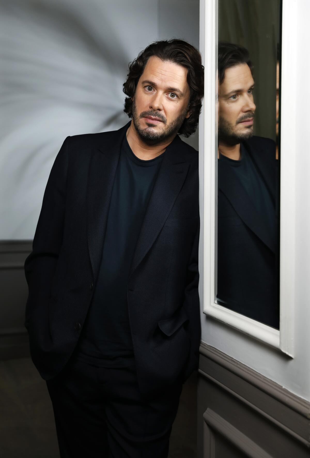 Writer-director Edgar Wright leans against a mirror, reflecting a second image of his face. 