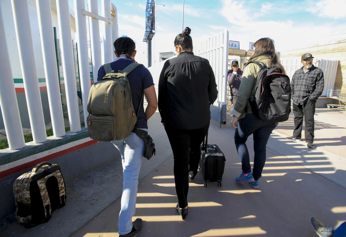At the PedWest port of entry in Tijuana, Margaret Cargioli (r), managing attorney for Immigrant Defenders Law Center in San Diego walks with Jose, 20 (l) and Casey Revkin (r) director at Immigrant Families Together towards the U.S. port of entry in San Ysidro. After not being allowed to cross on December 6th, Cargioli on Tuesday, December 10, 2019 tried again with Jose and on her second attempt was allowed to cross into the U.S. with her Jose.