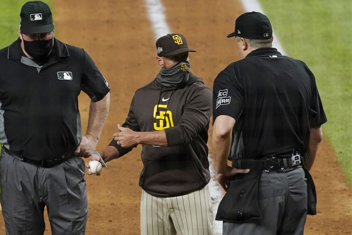 San Diego Padres manager Jayce Tingler, center, argues with home plate umpire Lance Barrett, right, during the sixth inning in Game 1 of a baseball NL Division Series against the Los Angeles Dodgers, Tuesday, Oct. 6, 2020, in Arlington, Texas. (AP Photo/Tony Gutierrez)