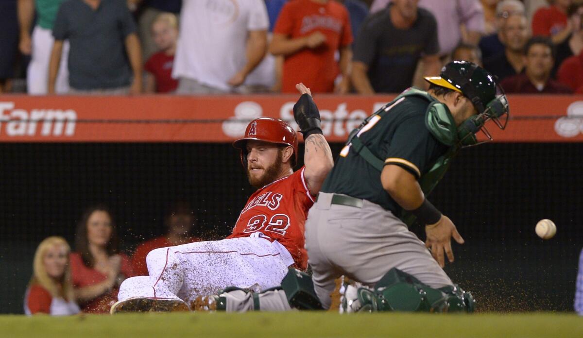 Josh Hamilton slides in to home plate ahead of the throw to Oakland catcher Geovany Soto during the second inning.