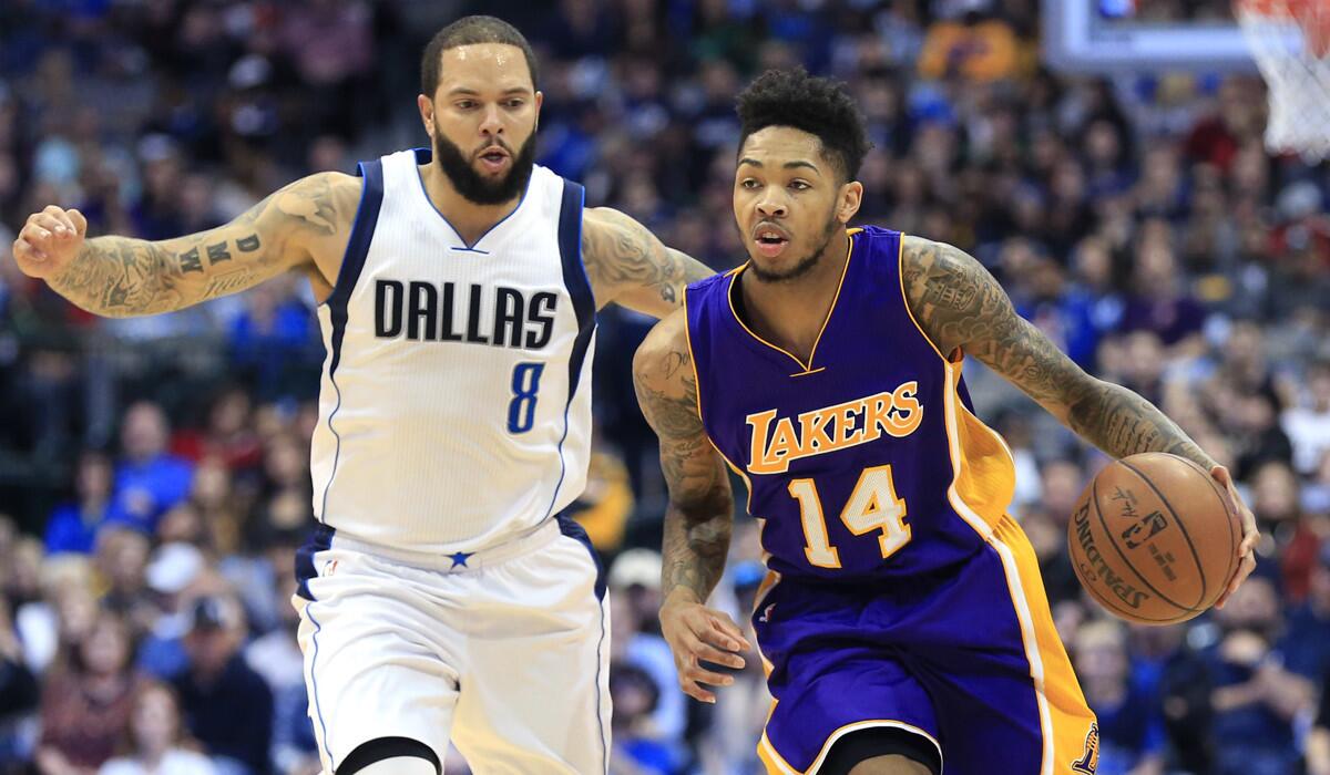 Lakers forward Brandon Ingram (14) dribbles past Dallas Mavericks guard Deron Williams (8) during the first half Sunday.