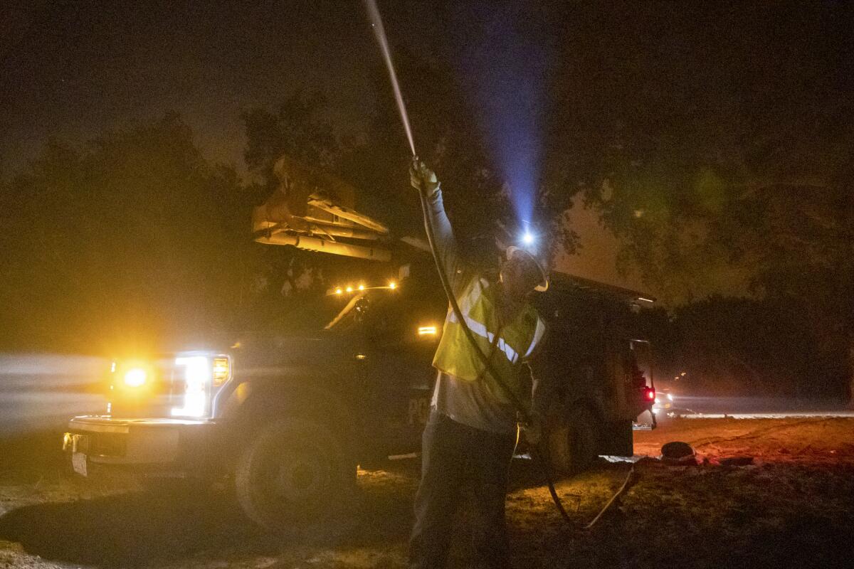 PG&E employee sprays water on burning telephone pole