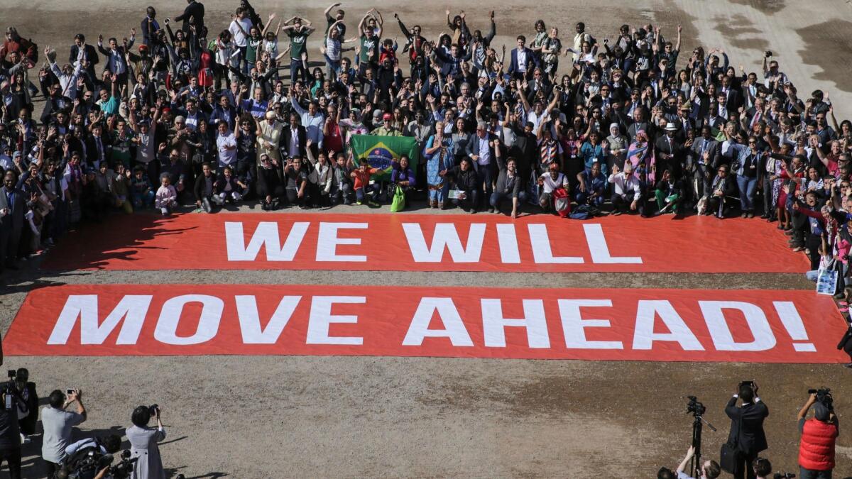 Participants at United Nations climate talks in Marrakech, Morocco, show their support for a landmark agreement reached in Paris last year.