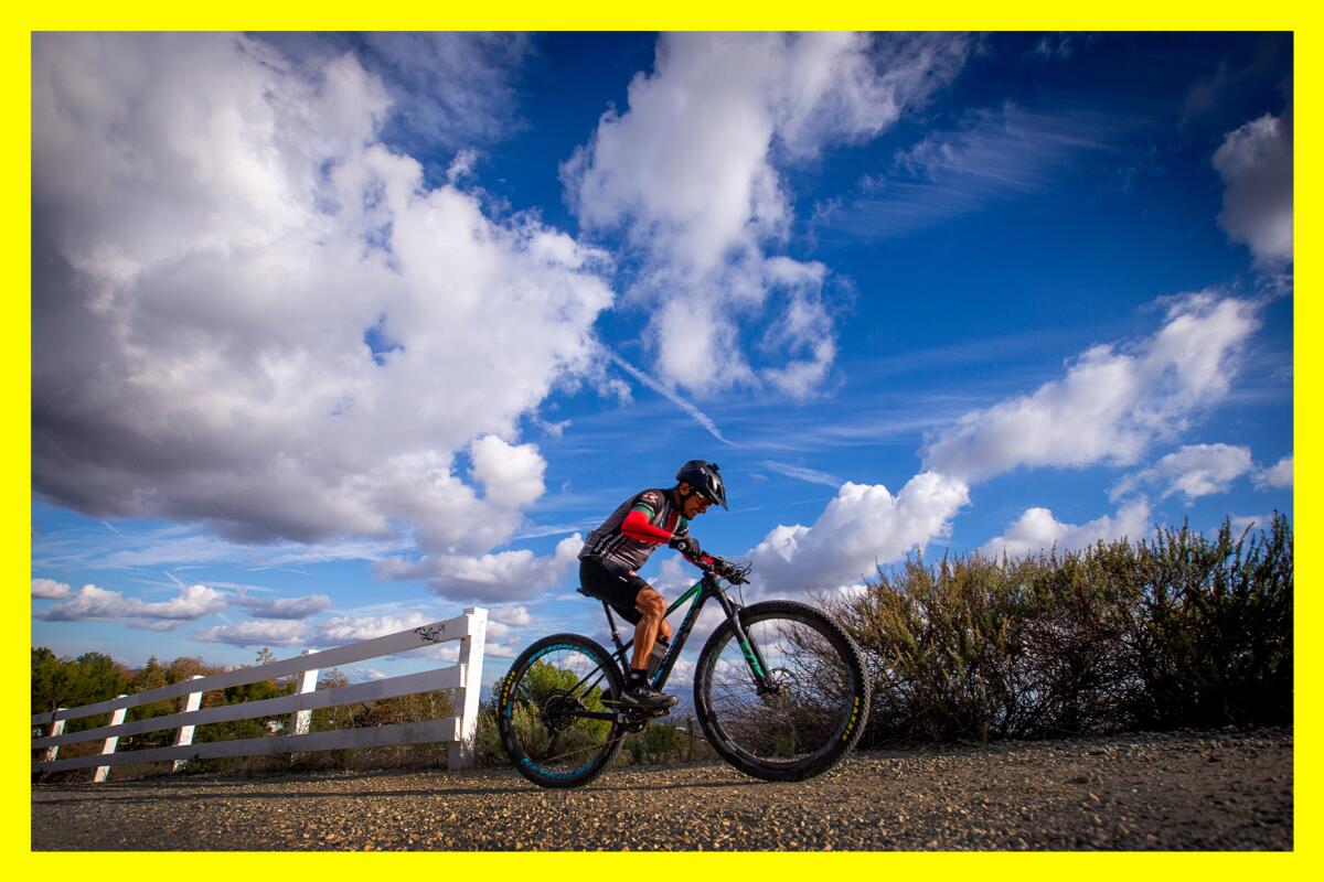 A mountain biker takes a scenic ride up a hill overlooking Orange and Los Angeles counties.