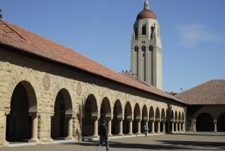 People walk on the Stanford University campus beneath Hoover Tower.