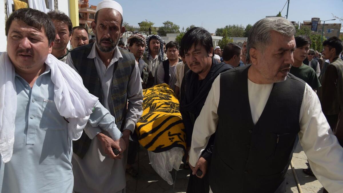 Afghan mourners carry a victim's coffin a day after the attack on a Shiite mosque.