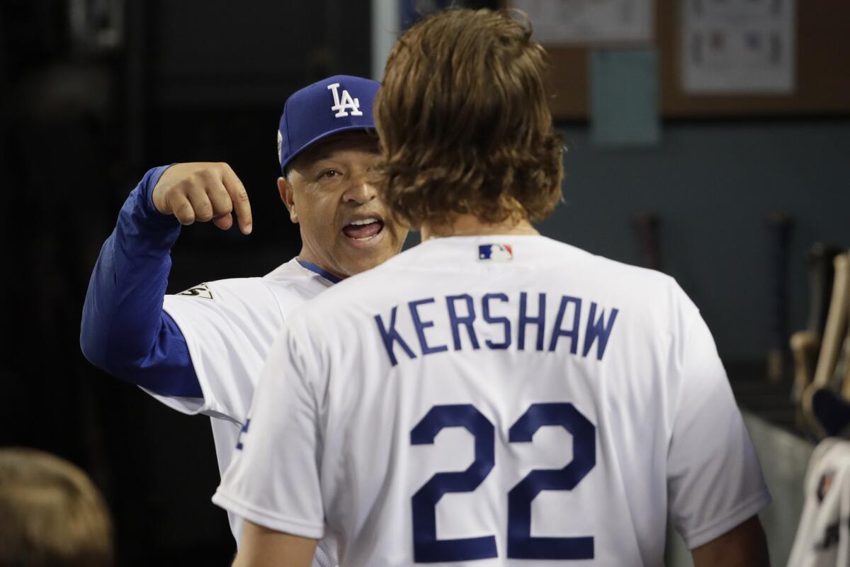 Manager Dave Roberts talks with Clayton Kershaw, who pitched four scoreless inning in relief, after the sixth inning of Game 7.