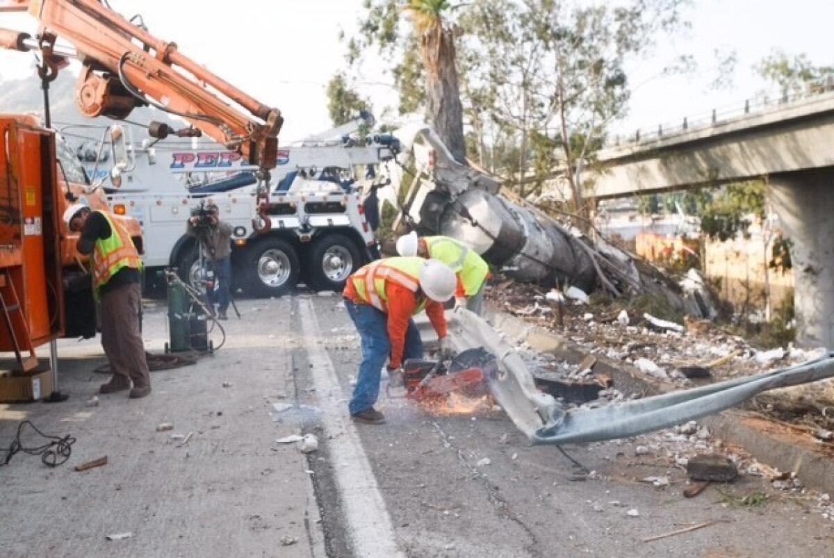 Crews work to remove debris from an overturned tanker carrying milk on the southbound Glendale (2) Freeway in Glendale.
