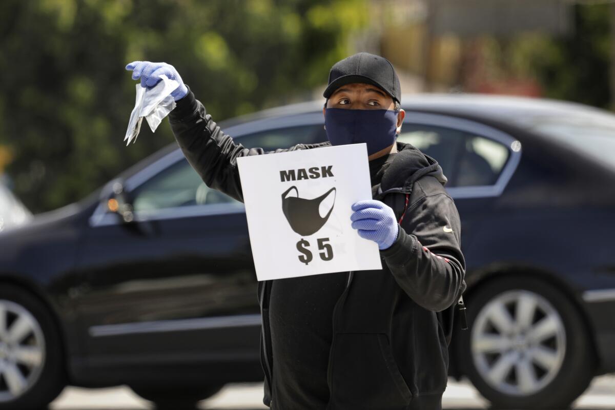 A man sells masks for $5 each on the street in Echo Park on April 3.