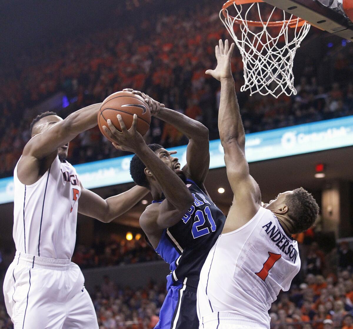 Virginia forward Darion Atkins, left, fouls Duke forward Amile Jefferson (21) during the first half of a game Jan. 31.