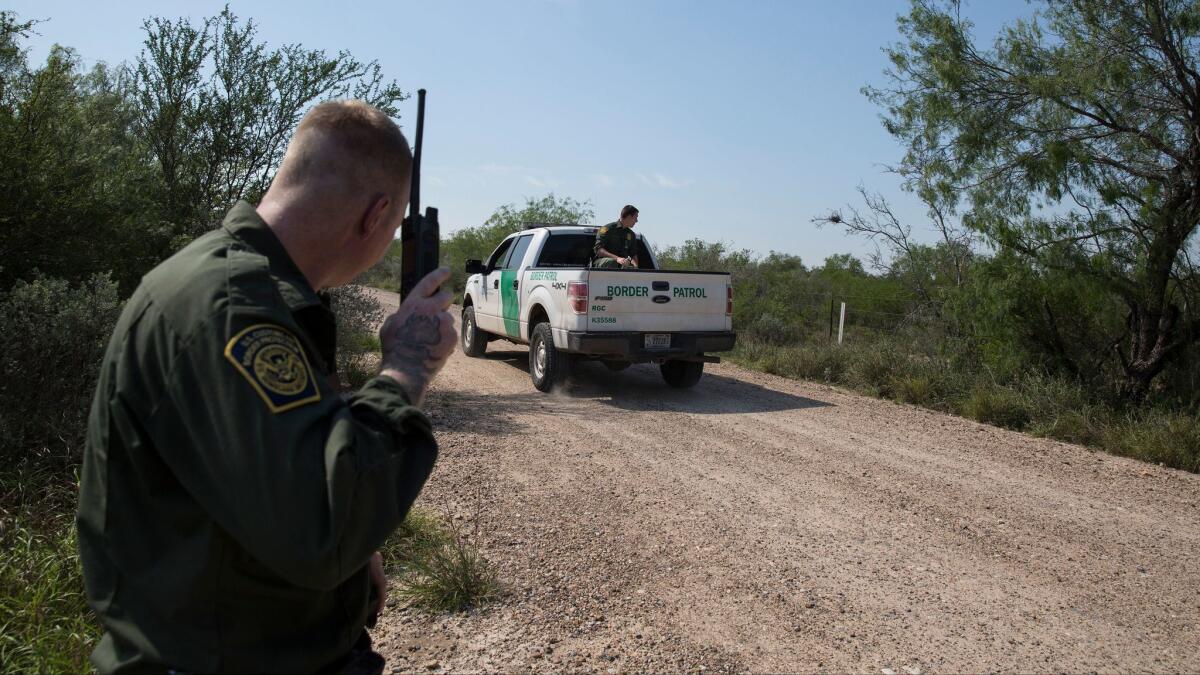 U.S. Border Patrol Agent Dave Thomas monitors radio traffic as agents search heavy brush for migrants identified earlier in the day by airborne surveillance after they illegally crossed the Rio Grande in Fronton, Texas.