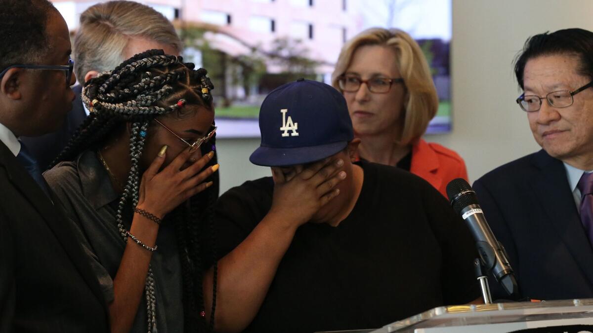 Students Myriah Smiley, 19, and Norma Castillo, 32, break down at the podium during a press conference at the Los Angeles Trade Technical College.