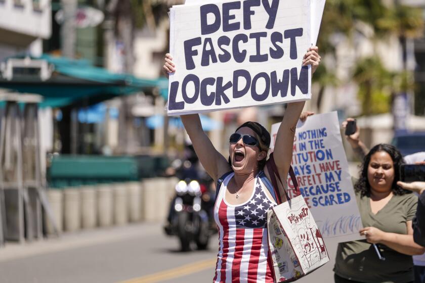 HUNTINGTON BEACH, CA - APRIL 17: Sarah Mason, from Covina, at a rally against the lockdown due to coronavirus pandemic. A big number of Trump supporters rally on Main Street against business closure due to COVID-19 pandemic. Huntington Beach, CA. (Irfan Khan / Los Angeles Times)