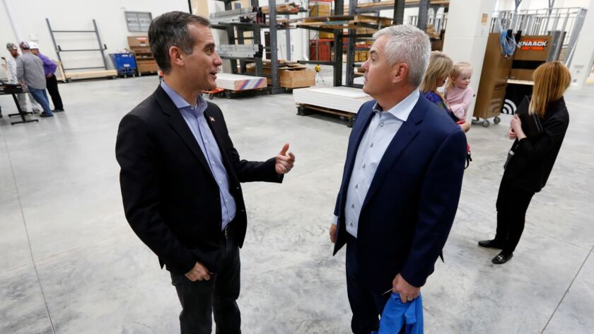 Los Angeles Mayor Eric Garcetti, left, talks with Altoona Mayor Dean O'Connor during a tour of a carpenters training facility in Altoona, Iowa.