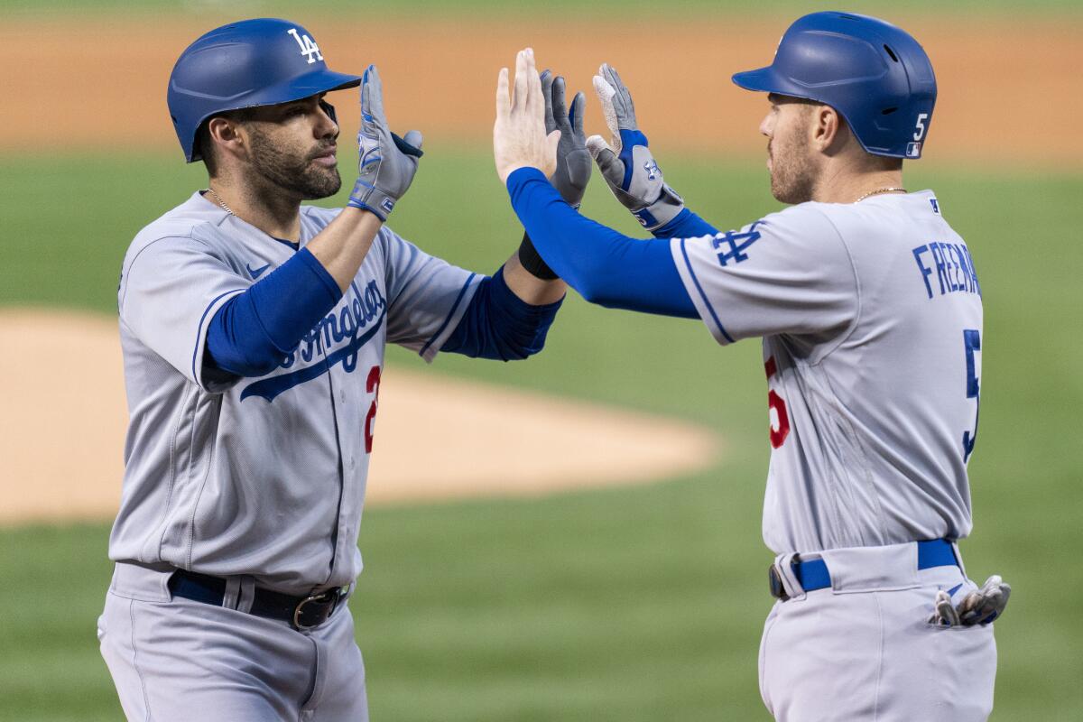 Dodgers designated hitter J.D. Martinez celebrates with Freddie Freeman after hitting a two-run home run.