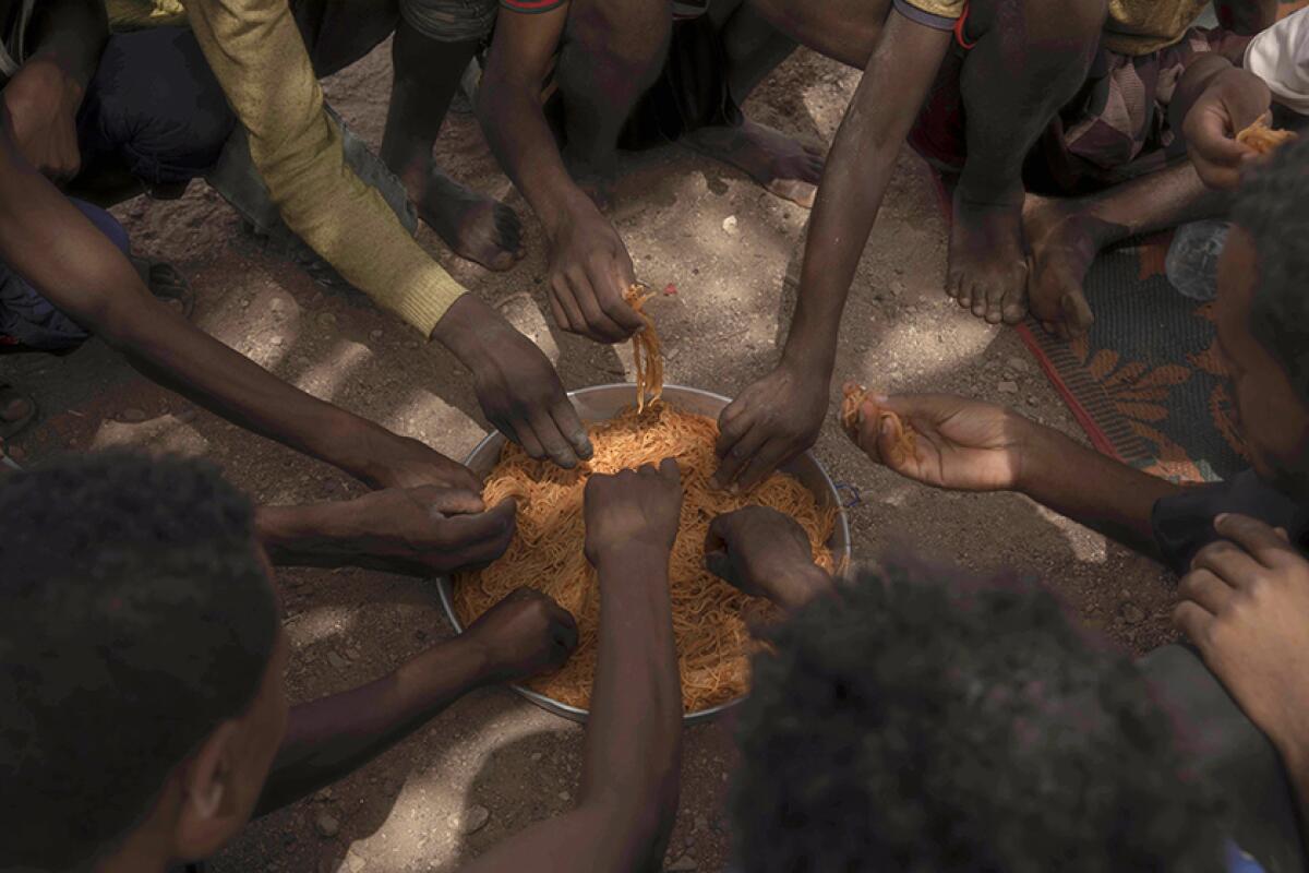 Migrants share spaghetti in Obock, Djibouti.