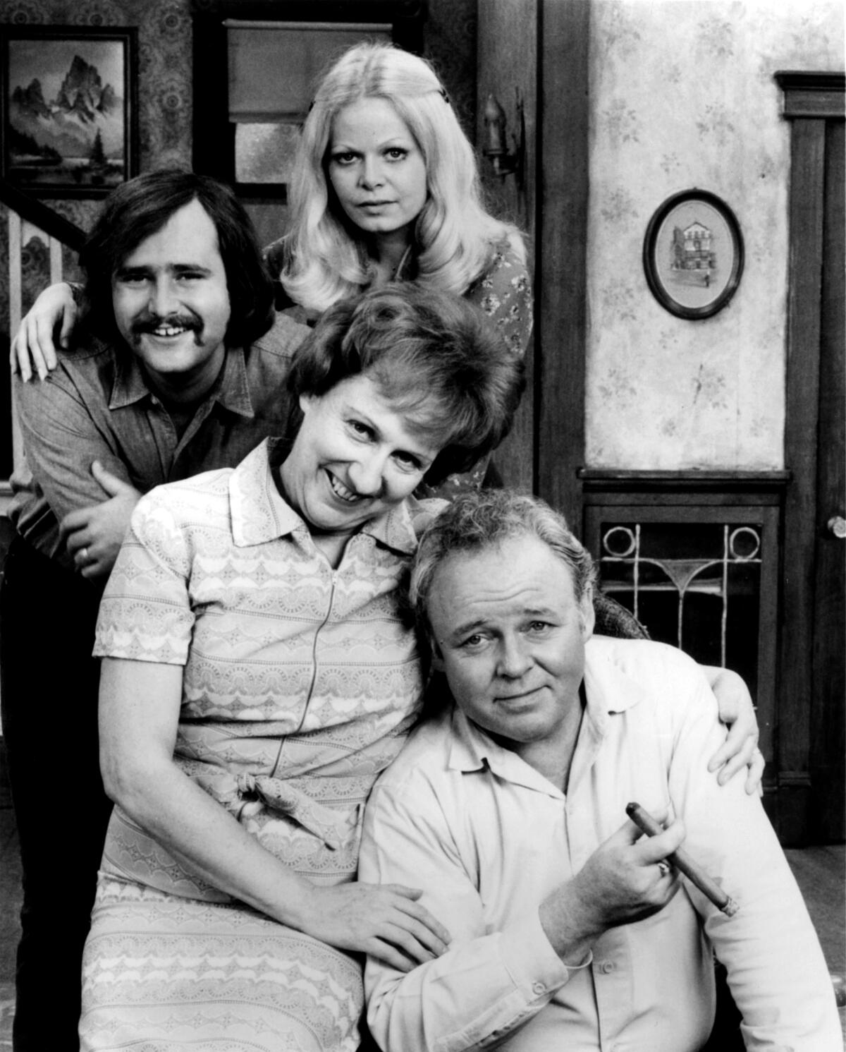 The four main characters from the '70s series "All in the Family" pose for a photo in Archie Bunker's living room.
