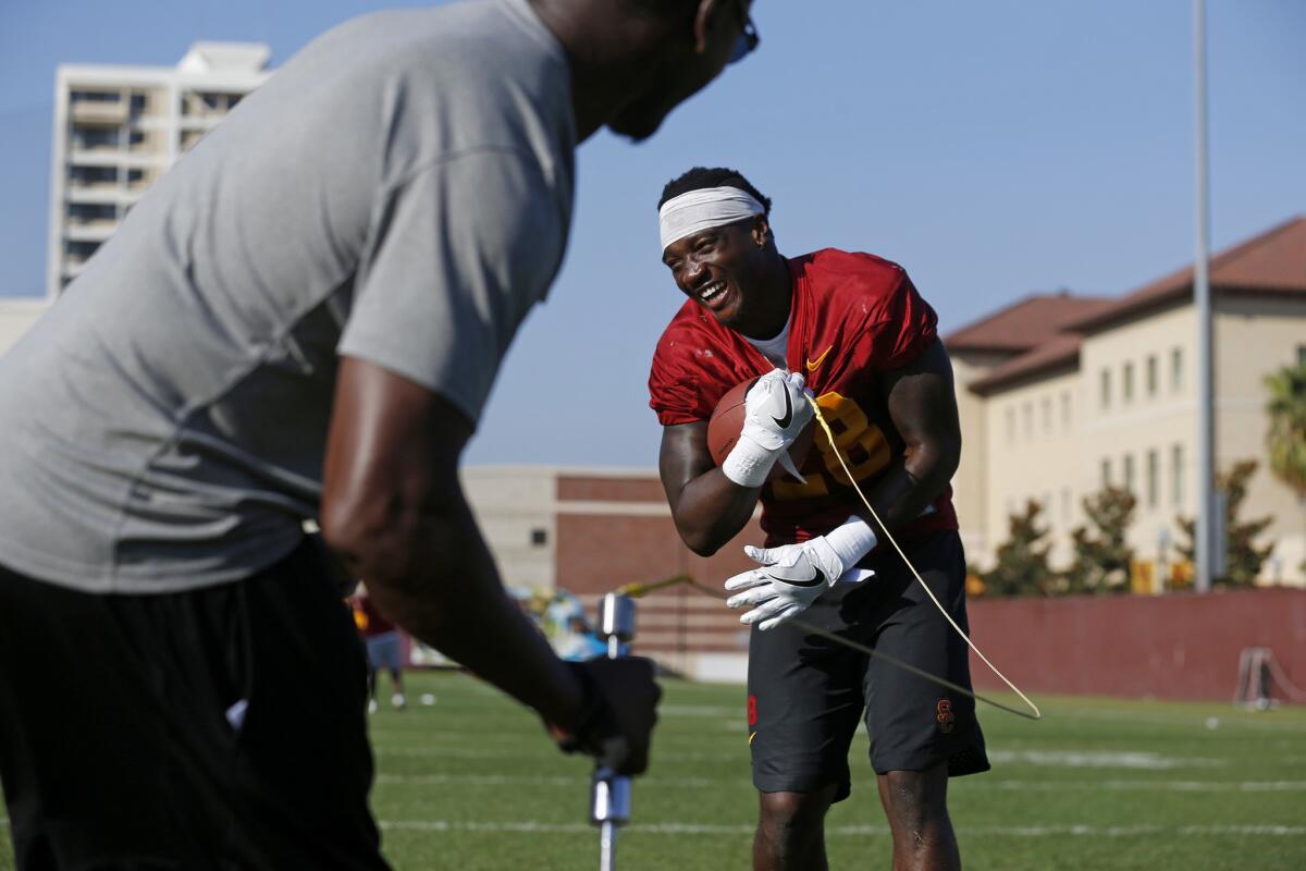 USC running backs coach Deland McCullough, left, demonstrates how Fumble Pro is used with running back Aca'Cedric Ware.
