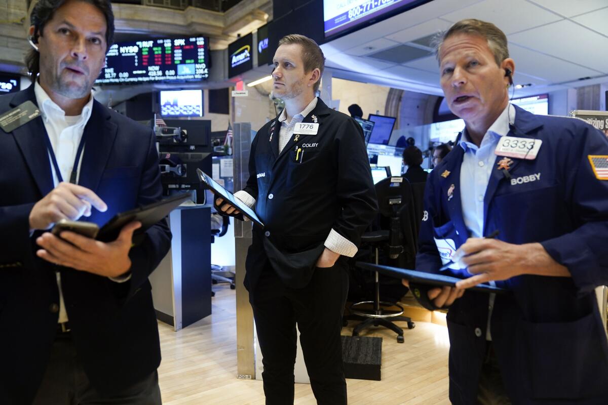 Three men standing with tablet computers.