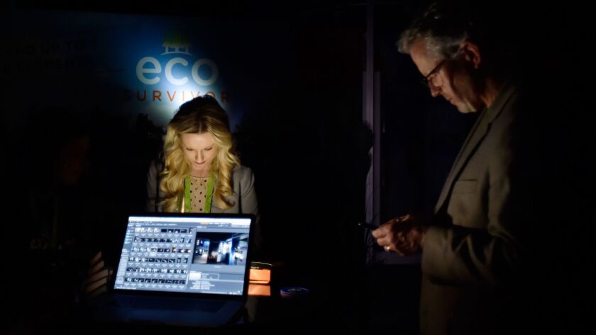 CES attendees use the light of their electronic devices at the Jasco Products booth after power went out inside the central hall at the Las Vegas Convention Center on Wednesday.