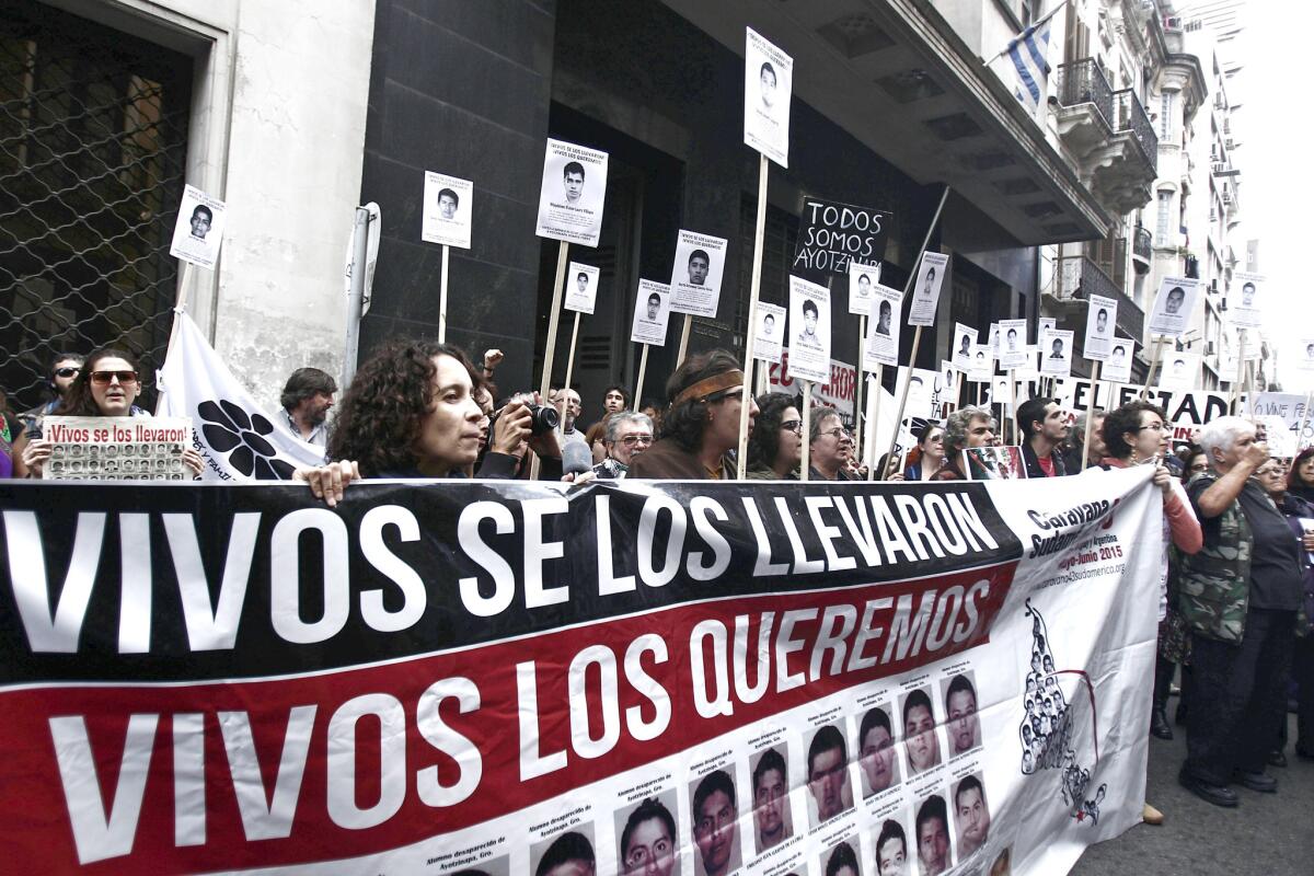 Decenas de personas con carteles y pancartas participan en una manifestación de apoyo a los compañeros y familiares de los 43 estudiantes desaparecidos hace ocho meses en el estado mexicano de Guerrero.