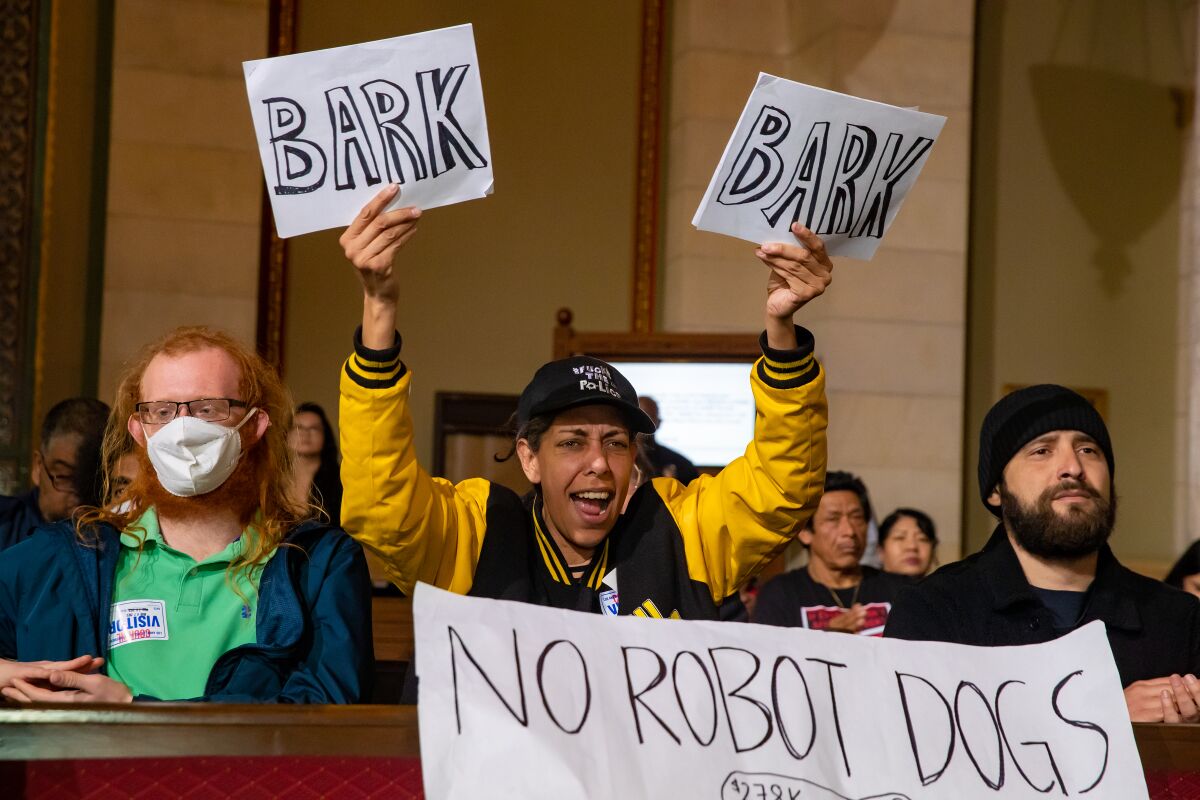A City Council audience member voices opposition to the proposed donation of a dog-like robot to the LAPD.