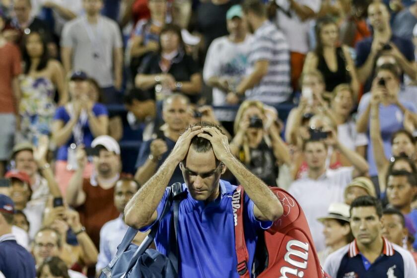 Roger Federer walks off the court after losing to Tommy Robredo in a fourth-round upset at the U.S. Open on Monday.
