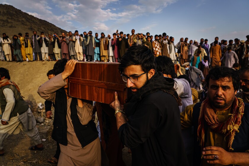Caskets of the dead are carried at a mass funeral for civilians killed in a U.S. drone strike in August.