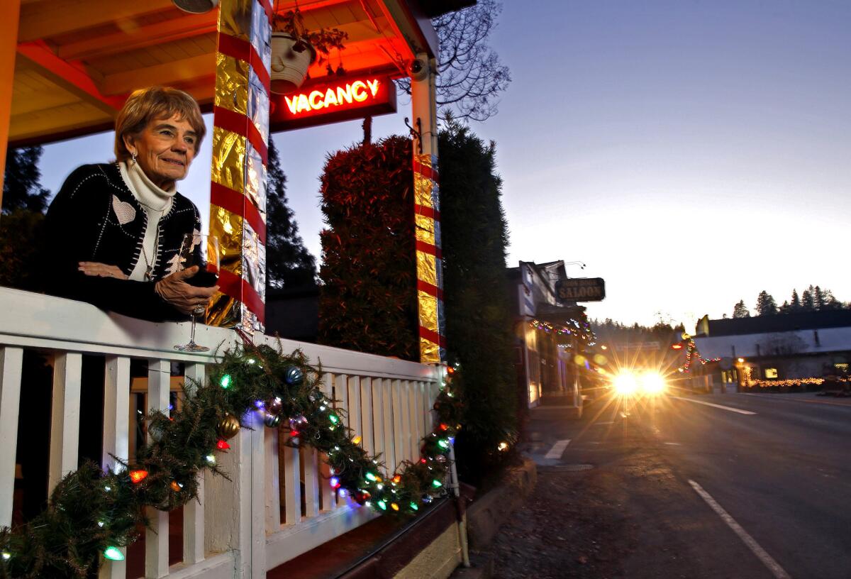 Peggy Mosley, 79, owner of the Groveland Hotel, stands on the porch overlooking California 120. The vacancy sign has been lit since the Rim wildfire burned to the edge of town and dried up her business. The tragedy was preceded by the death of her husband of 55 years just as the Rim fire started raging out of control in August 2013. Then the federal government shutdown kept nearby Yosemite National Park closed, robbing her of the tourists she and the Gold Rush-era town thrive on.