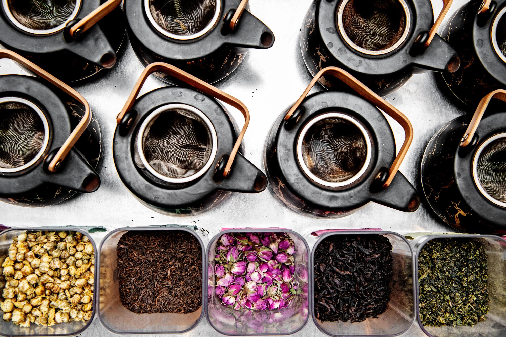An overhead view of various teapots and boxes of loose-leaf tea.