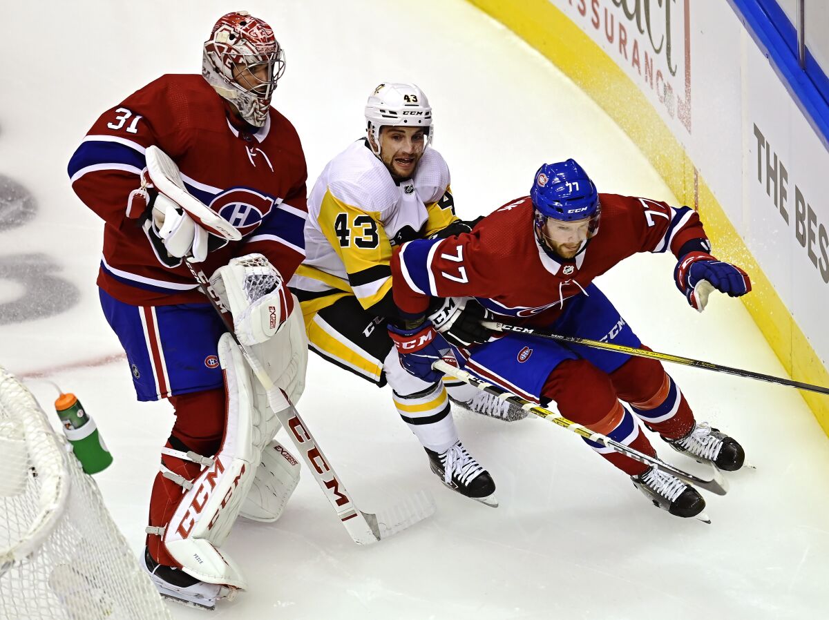 Montreal Canadiens goaltender Carey Price (31) stays out of the way as Pittsburgh Penguins' Conor Sheary (43) chases Canadiens' Brett Kulak (77) during first period NHL Eastern Conference Stanley Cup playoff action in Toronto on Wednesday, Aug. 5, 2020. (Frank Gunn/The Canadian Press via AP)