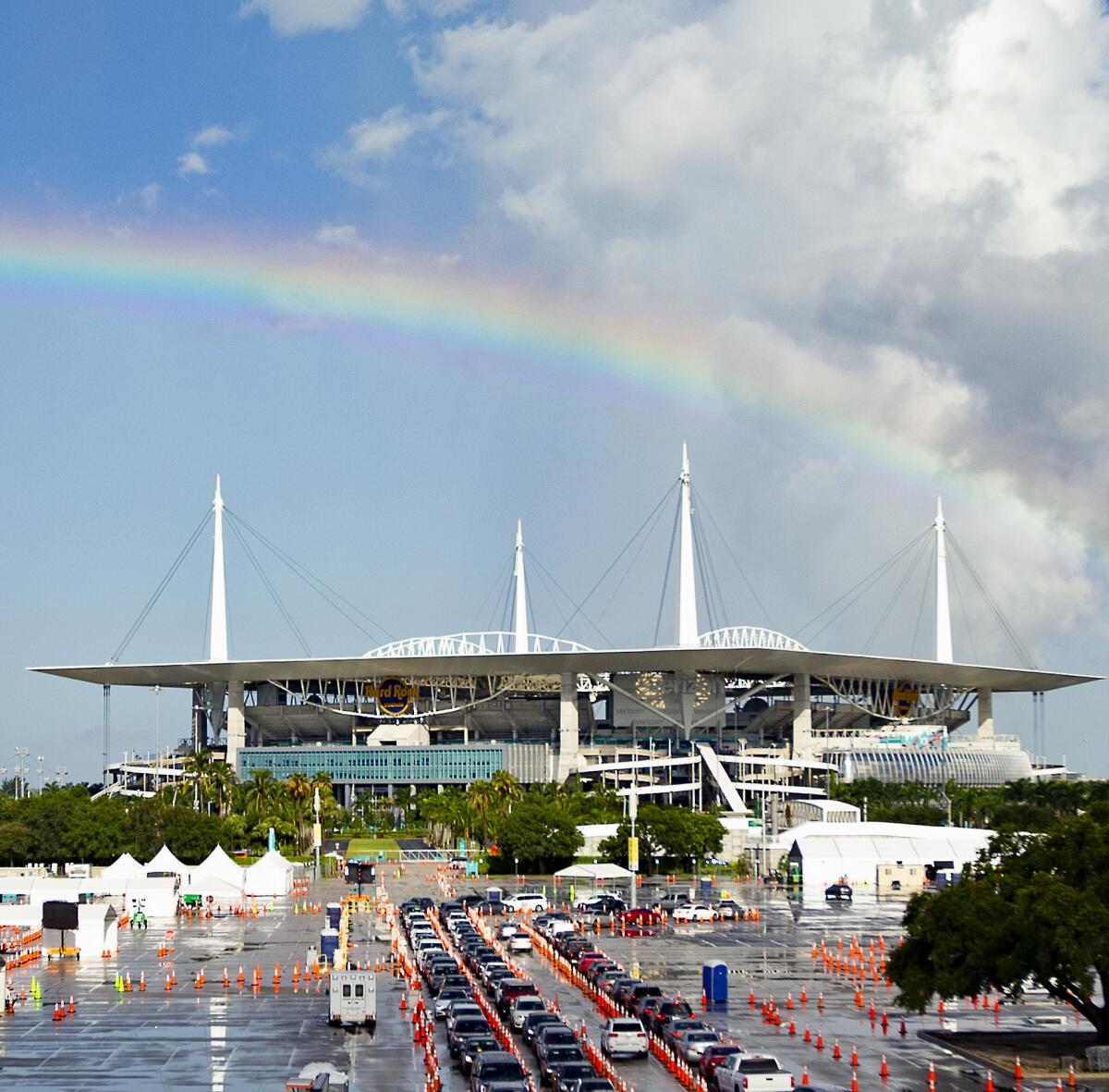 A view of a rainbow as vehicles line up at a COVID-19 drive-through testing center in Miami