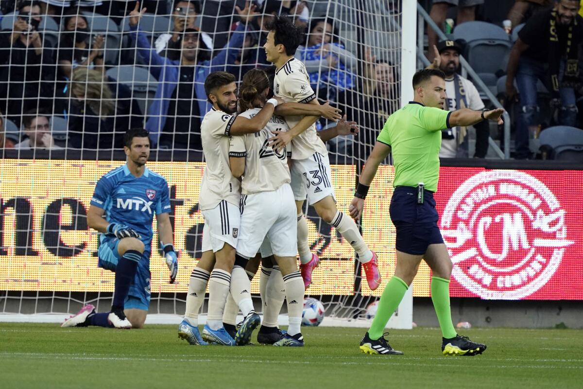 Los Angeles FC players, mob, forward Carlos Vela, obscured, 