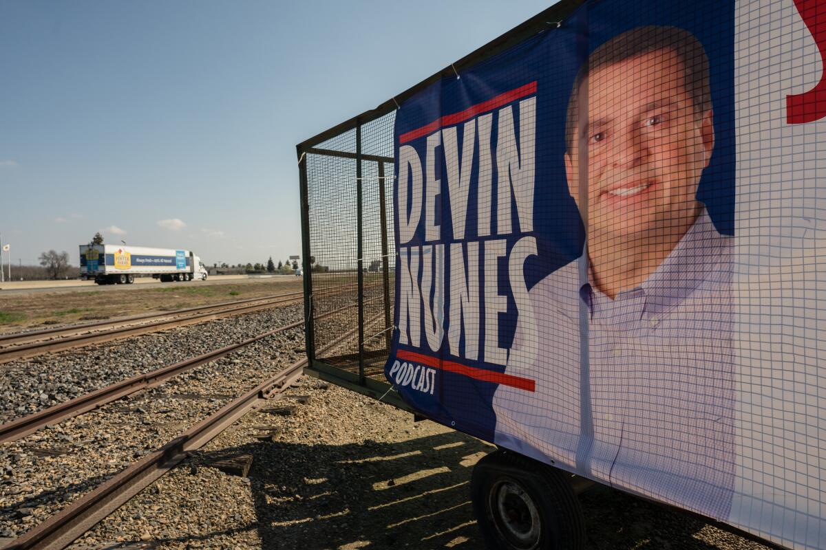 A sign behind a protective barrier has a large picture of Nunes and his name in capital letters.