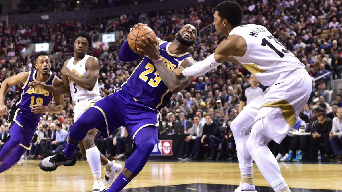 Lakers forward LeBron James starts to fall to the court after being fouled by Toronto Raptors forward Malcolm Miller during the second half on Thursday in Toronto.