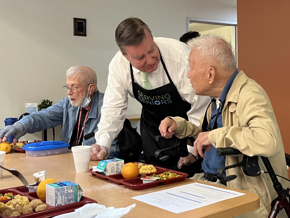 San Diego County Supervisor Joel Anderson serves lunch to a client at the Gary and Mary West Senior Wellness Center..