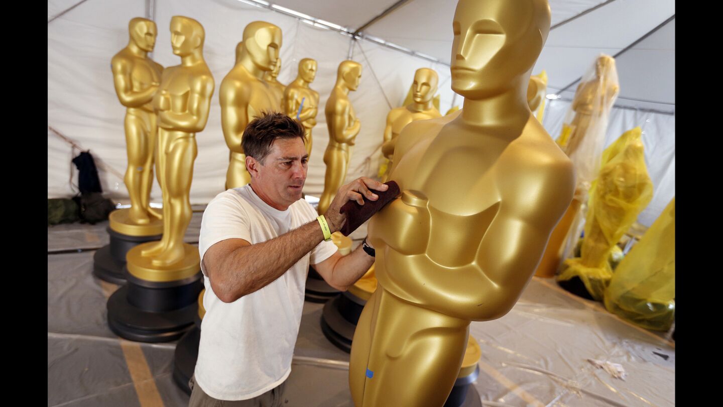 Scenic artist Derek Medevic gets one of the many Oscar statue props in top condition ahead of Sunday's Academy Awards.