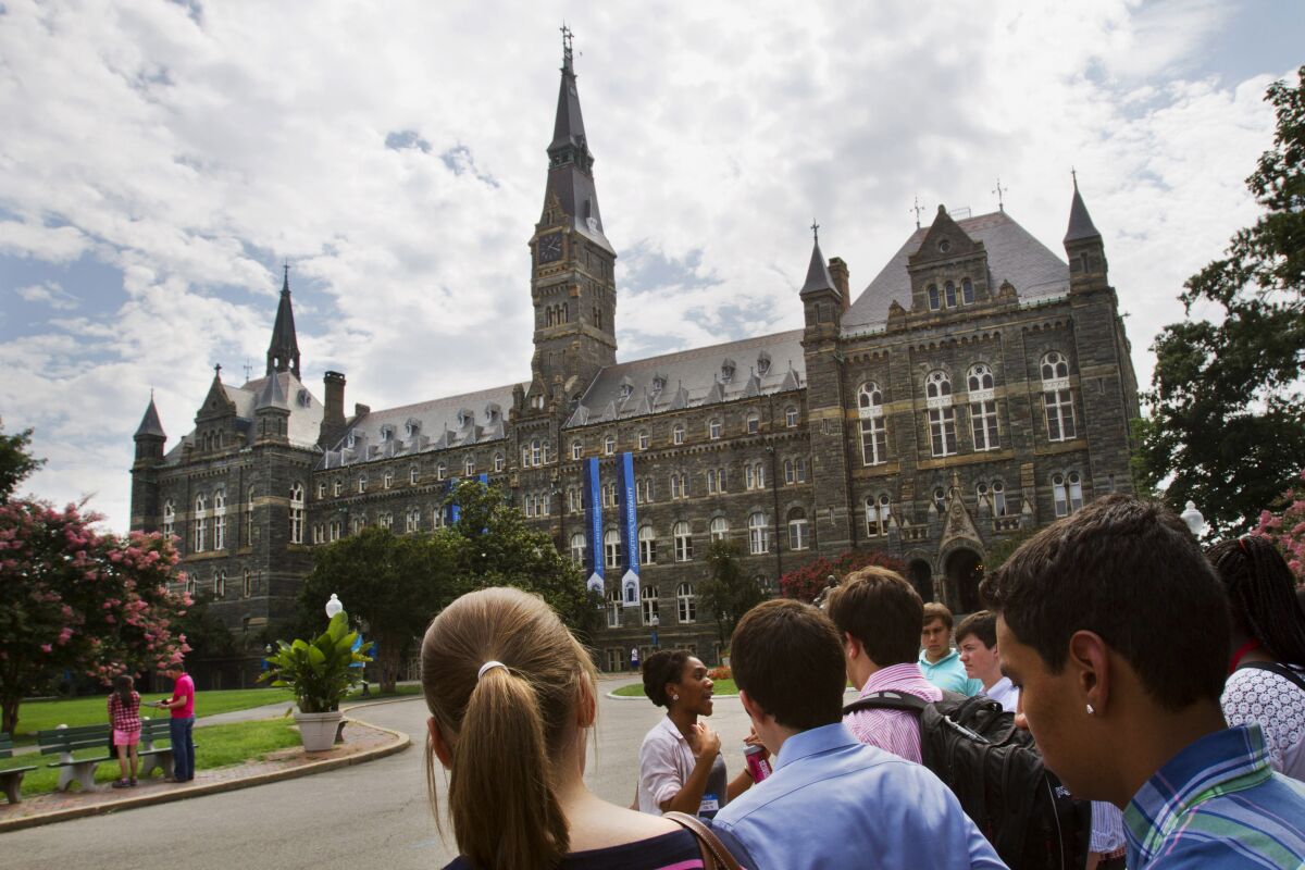 FILE - Prospective students tour Georgetown University's campus, on July 10, 2013, in Washington. Amin Khoury is scheduled to stand trial Tuesday June 7, 2022, in Boston, on charges that he bribed Georgetown University tennis coach Gordon Ernst to get his daughter into the school as a recruit. (AP Photo/Jacquelyn Martin, File)