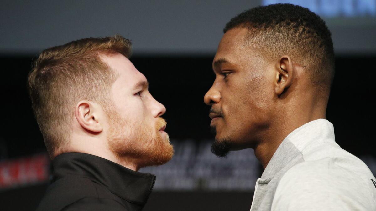 Canelo Alvarez, left, and Daniel Jacobs pose for photographers at a news conference for their middleweight title boxing match on Wednesday in Las Vegas. The two are scheduled to fight on Saturday.