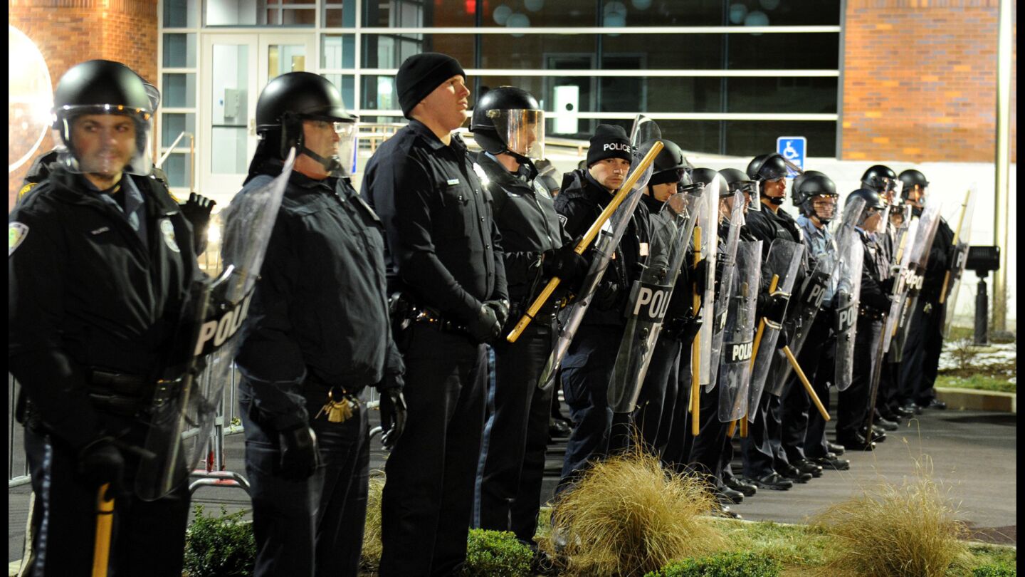 Police officers block the entrance to the Ferguson police station in Missouri on Nov. 19. About 40 demonstrators blocked streets while protesting the death of Michael Brown.