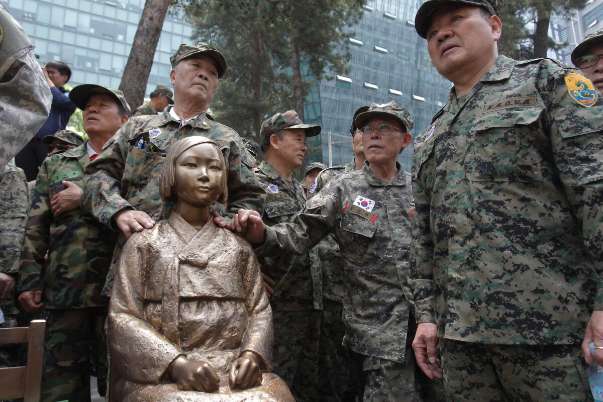 South Korean soldiers stand around a statue commemorating the so-called comfort women used as sex slaves by Japanese soldiers during World War II in a May photo taken at the Japanese Embassy in Seoul. A similar monument is planned in Glendale to mark Korean Comfort Women Day on July 30.