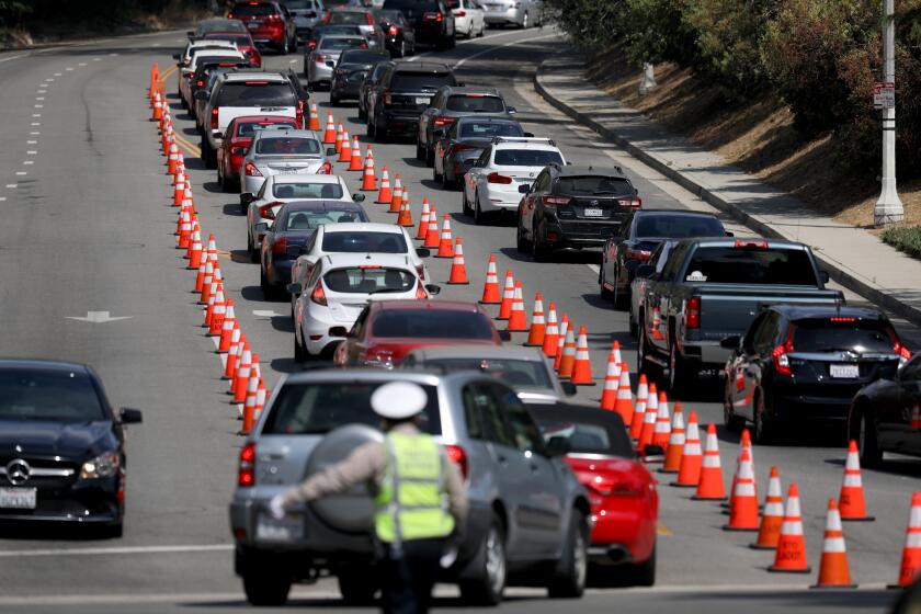 LOS ANGELES, CA - JUNE 25: People wait in line to have a Covid-19 screening administered by the Community Organized Relief Effort at the Los Angeles City Mayor's Covid-19 test site at Dodger Stadium on Thursday, June 25, 2020 in Los Angeles, CA. The line of traffic is shown leading up to the entrance of Dodger Stadium at Stadium Way and Scott. 6000 people had registered for the coronavirus screening for today. (Gary Coronado / Los Angeles Times)