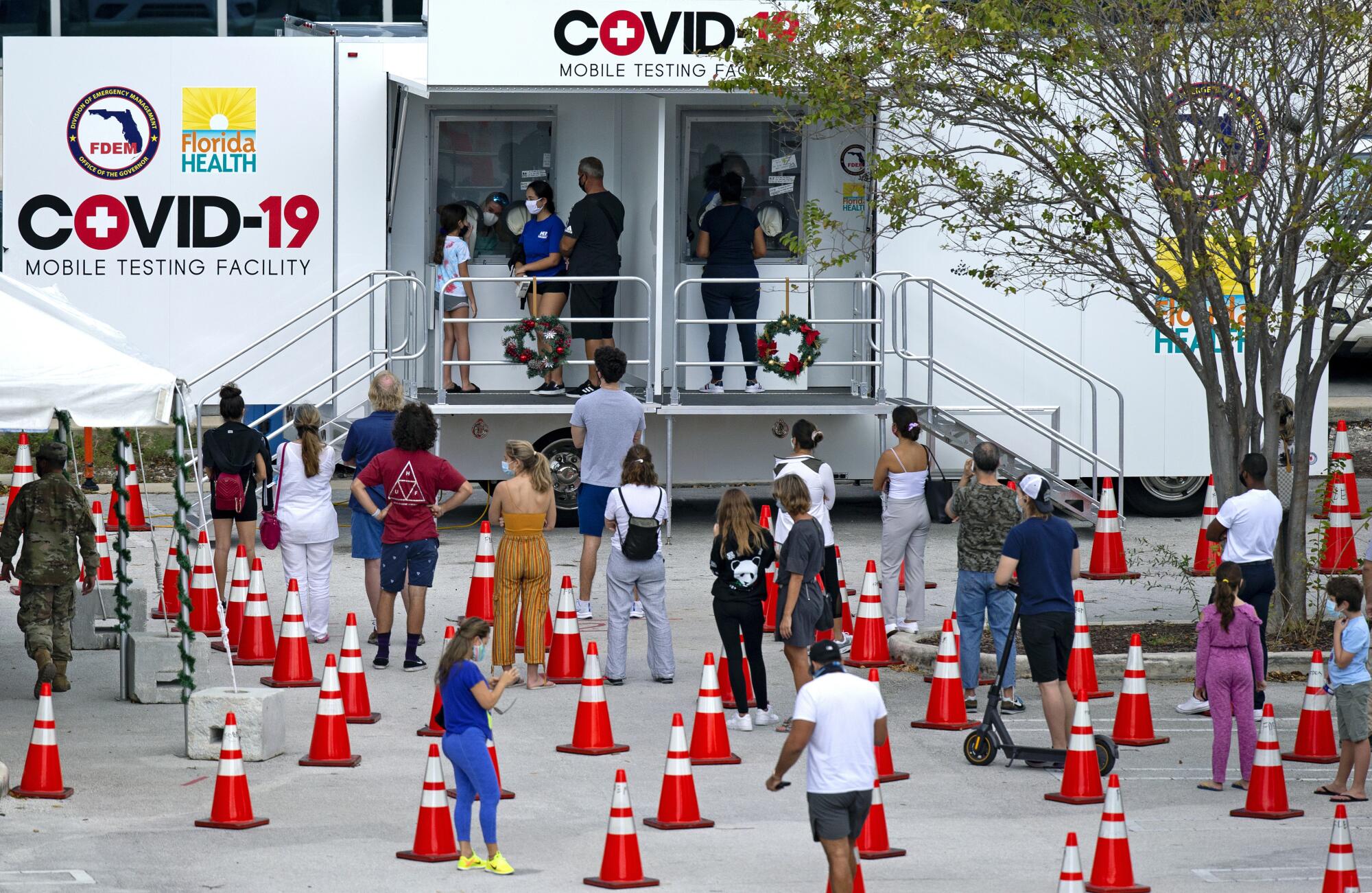 People stand in line to be tested at a coronavirus testing facility in Miami.