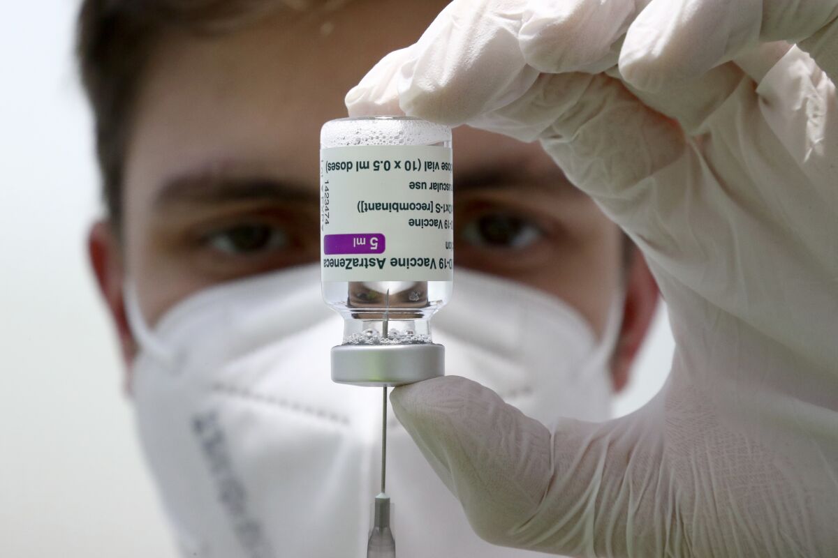 FILE-Medical staff prepares a syringe from a vial of the AstraZeneca coronavirus vaccine during preparations at the vaccine center in Ebersberg near Munich, Germany, Monday, March 22, 2021. AstraZeneca said Thursday that it is withdrawing its application for approval of its COVID-19 vaccine in Switzerland because the country's medical regulator wanted to restrict its use to people over 50. (AP Photo/Matthias Schrader, FILE)